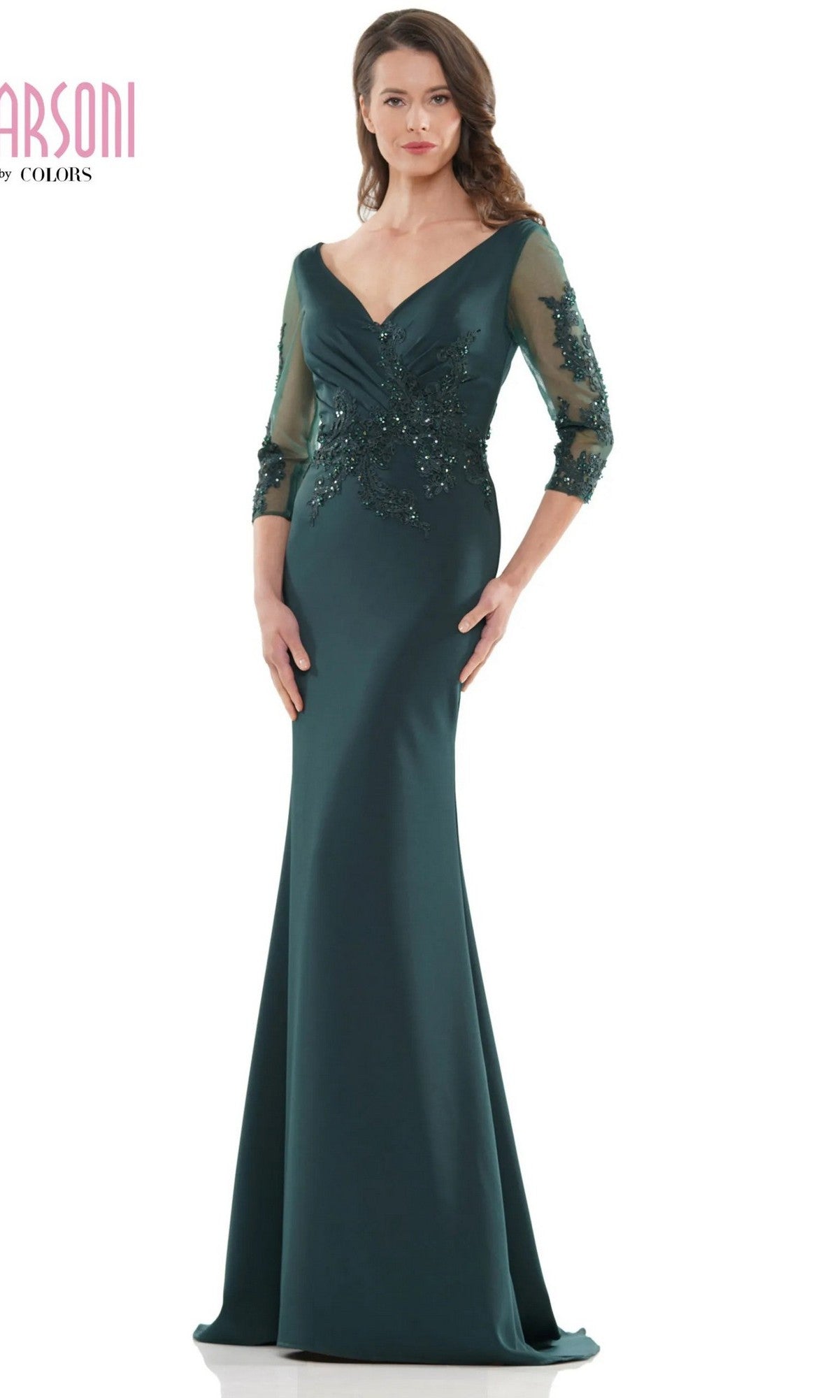A woman stands facing forward in the Marsoni MV1145 long formal dress, deep green in color, featuring sheer three-quarter sleeves and beaded embellishments.